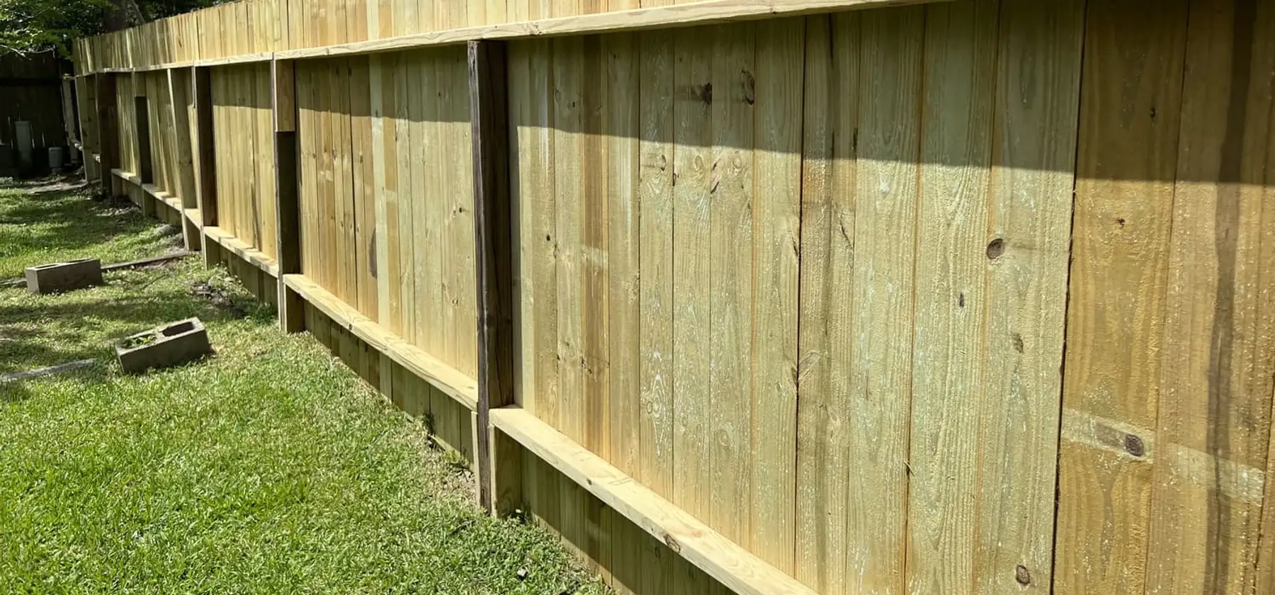 New wood privacy fence built along a back yard line on an OAFC Renovations job
