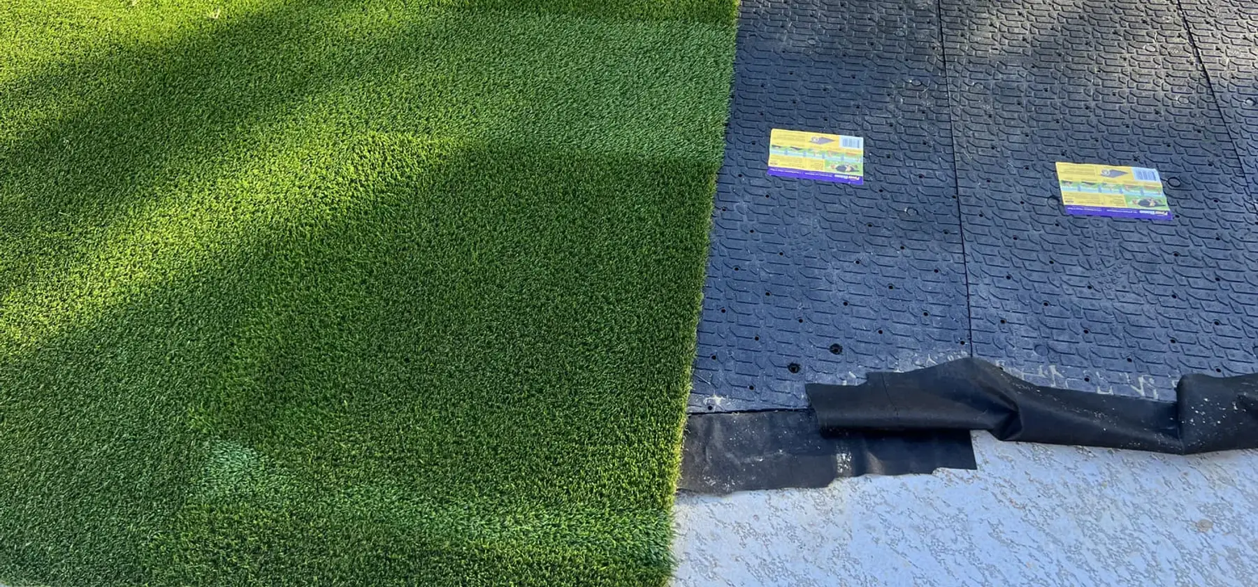 Artificial grass being laid over a prepared base on an OAFC Renovations job