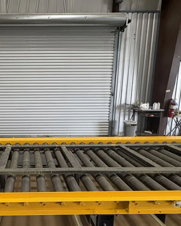 Commercial warehouse loading dock with yellow safety rails and pallet racking installed